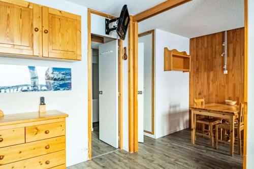 - une cuisine et une salle à manger avec des placards en bois et une table dans l'établissement Résidence Le Sapporo - Studio divisible 4/5 pers - WIFI - LE SAPPORO - PLAGNE VILLAGES MAE-6034, à Aime La Plagne
