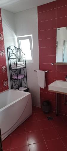 a red bathroom with a white tub and a sink at Klara in Vodice