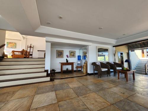 a living room with stairs and a table and chairs at Pousada Dreamland Buzios in Búzios