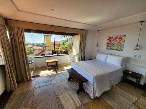 a hotel room with a bed and a large window at Pousada Dreamland Buzios in Búzios