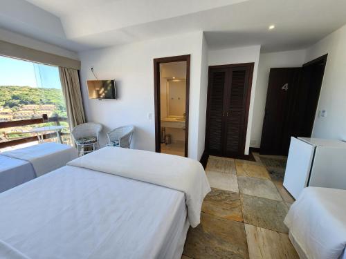 a hotel room with two beds and a balcony at Pousada Dreamland Buzios in Búzios
