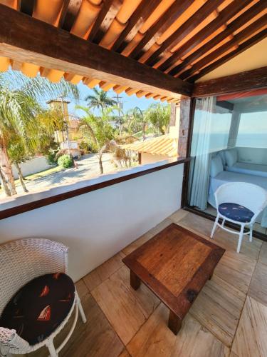 a screened in porch with a table and a chair at Pousada Dreamland Buzios in Búzios