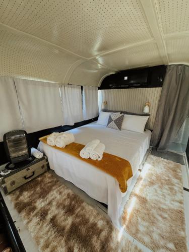 1 dormitorio con 1 cama en la parte trasera de una furgoneta en Hosperdagem no Ônibus Off White em Santa Teresa no Circuito Caravaggio, en Santa Teresa