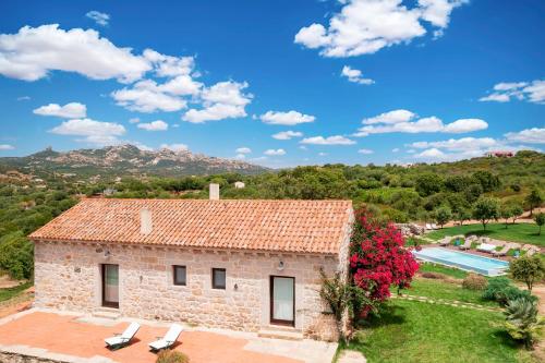 an external view of a stone house with a swimming pool at North Sardinia Retreats Stazzo Liccia Barria - villa con piscina in Arzachena
