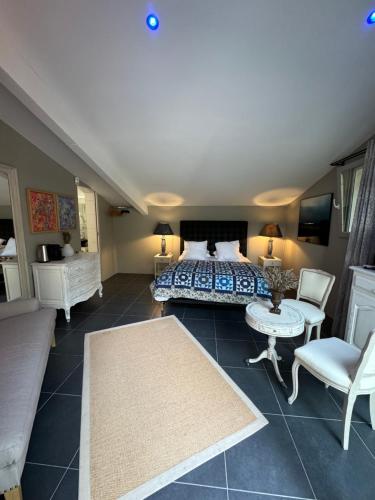 une chambre avec un lit, une table et des chaises dans l'établissement Les Feuilleres, à LʼIsle-sur-la-Sorgue