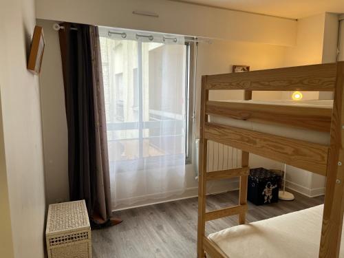 une chambre avec un lit superposé et une fenêtre dans l'établissement Proche de la Campagne à Paris, à Paris