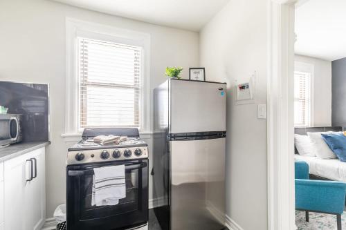 a kitchen with a refrigerator and a stove at Modern Apartment with Kitchen on James St in Hamilton