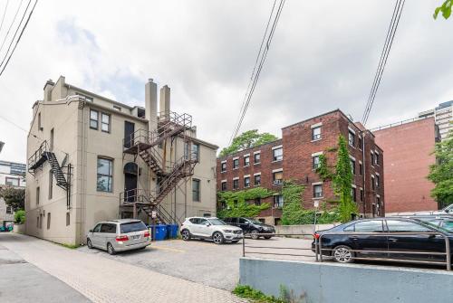 a building with cars parked in a parking lot at Modern Apartment with Kitchen on James St in Hamilton