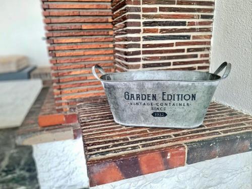 un seau assis sur le côté d'un mur de briques dans l'établissement L'Escale Marine à 2 mn à pied de la plage - 2CH, au Barcarès