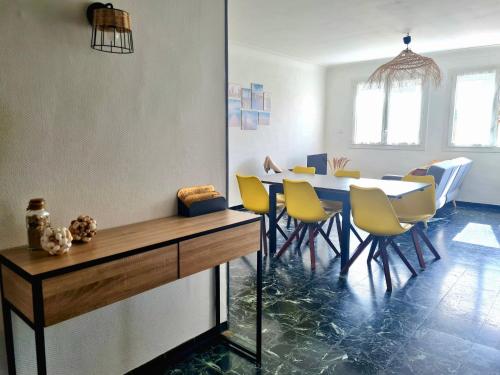 une salle à manger avec une table et des chaises jaunes dans l'établissement L'Escale Marine à 2 mn à pied de la plage - 2CH, au Barcarès