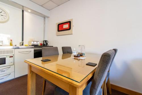 a kitchen with a wooden table and chairs at OYO The Bentleys Hotel in Newcastle upon Tyne