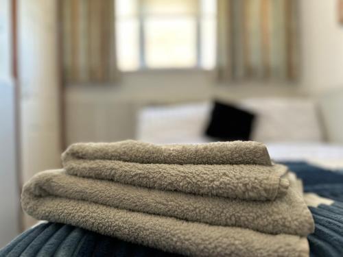 a pile of towels sitting on top of a bed at OYO The Bentleys Hotel in Newcastle upon Tyne