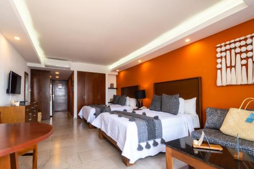 ein Hotelzimmer mit zwei Betten und einem Tisch in der Unterkunft The Paramar Beachfront Boutique Hotel With Breakfast Included - Downtown Malecon in Puerto Vallarta