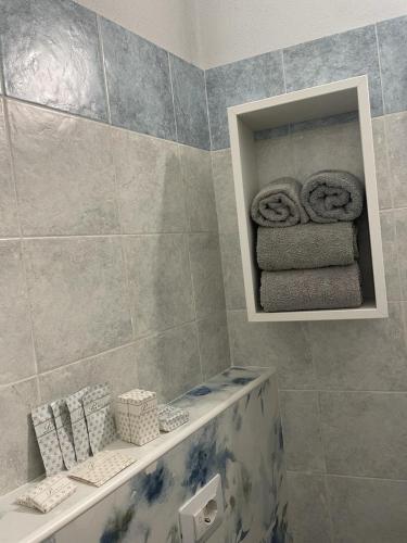 a bathroom with a tub and a shelf with towels at Asfodelo rooms in Bra