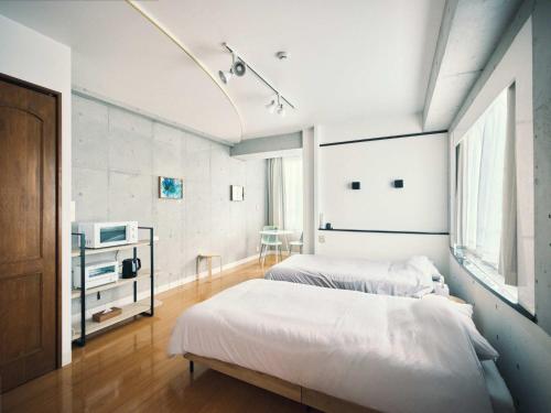 a bedroom with two beds and a television in it at vetta KumamotoCastle1003 Free Parking in Kumamoto
