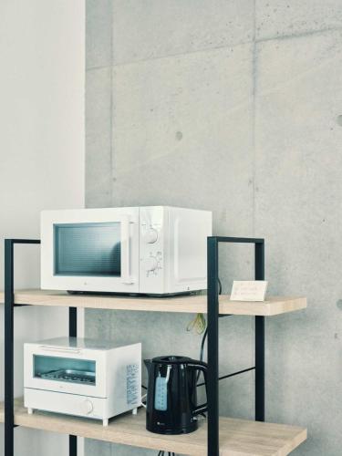 a microwave and a toaster oven on a shelf at vetta KumamotoCastle1003 Free Parking in Kumamoto