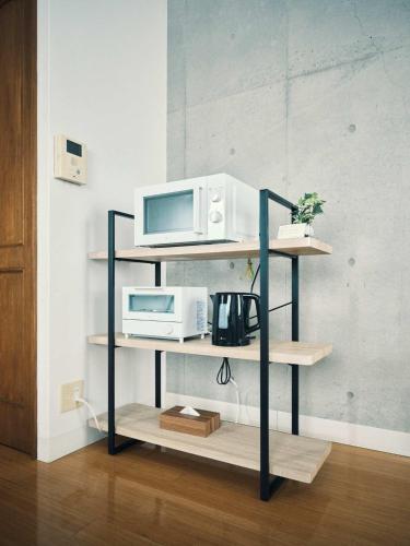 a shelf with two microwaves and a microwave on it at vetta KumamotoCastle1003 Free Parking in Kumamoto