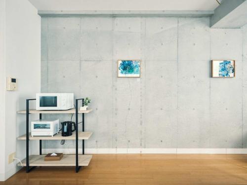 a living room with a microwave and a shelf with a microwave at vetta KumamotoCastle1003 in Kumamoto