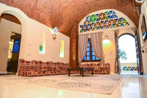 a living room with a bench and stained glass windows at Elmamora tunis in Kafr ‘Amr