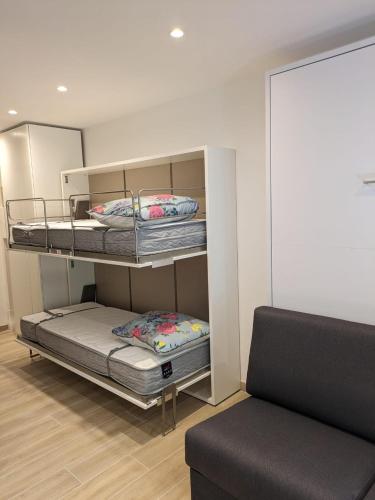 une chambre avec deux lits superposés et un canapé dans l'établissement Studio climatisé, parking, 5mn de la plage, à Saint-Cyr-sur-Mer