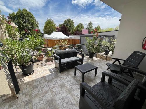a patio with furniture and plants on a balcony at City Apartman ház in Balatonlelle