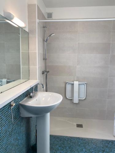 une salle de bain avec un lavabo et une douche dans l'établissement Citadine, à Montrouge