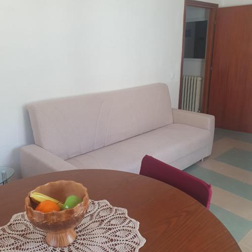 a living room with a couch and a bowl of fruit on a table at Discover Appennino - Via Roma 72, 12 - Montecreto in Montecreto