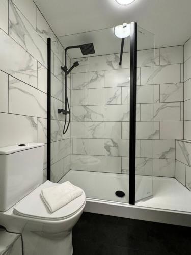 Un baño blanco con ducha y WC. en Nordic Suites Apartments, Ulverston, en Ulverston