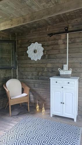 Cette chambre comprend une armoire blanche et une chaise. dans l'établissement Chalet en Ardèche, à Fabras