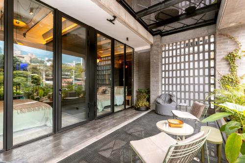 a patio with glass doors and a table and chairs at Primavera Luxury Apartments Medellin in Medellín
