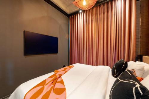 a bedroom with a bed with a television on the wall at Primavera Luxury Apartments Medellin in Medellín