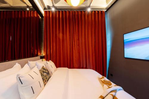 a hotel room with a bed with a flat screen tv at Primavera Luxury Apartments Medellin in Medellín