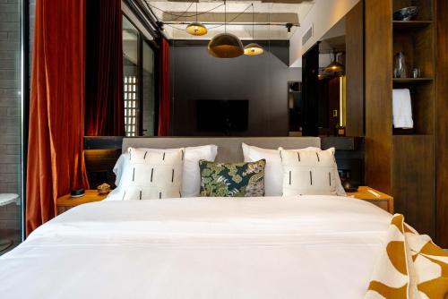 a bedroom with a large white bed with pillows at Primavera Luxury Apartments Medellin in Medellín