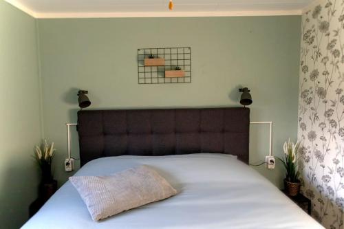 Un dormitorio con una gran cama blanca con cabecero. en Chalet Baaium, en Baijum