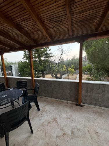 a patio with a table and chairs and a fence at Mani Spot in Almiro in Kyparissos
