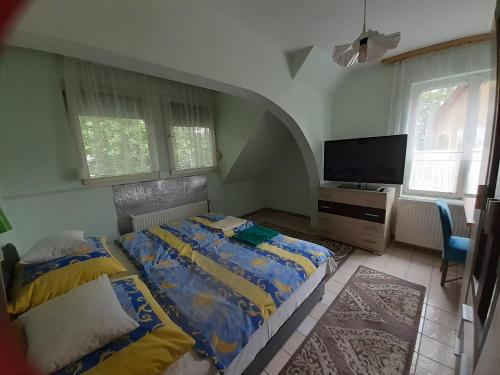 a bedroom with two beds and a flat screen tv at Prima Pihenő in Miskolctapolca