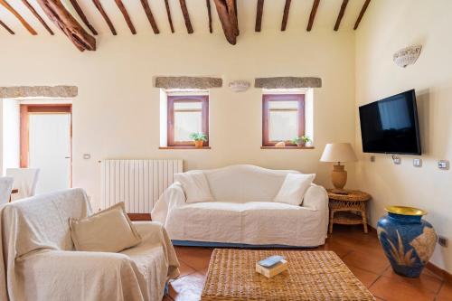 a living room with a white couch and a tv at North Sardinia Retreats Stazzo Liccia Barria - villa con piscina in Arzachena