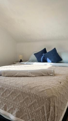 a bed with blue pillows on top of it at Agape Bed Airport in Santiago