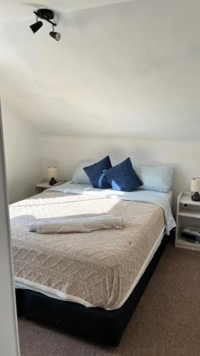 a bedroom with a bed with blue pillows on it at Agape Bed Airport in Santiago