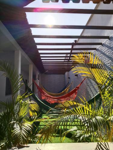 two hammocks in a room with palm trees at Pousada Nelly Medeiros in Carolina