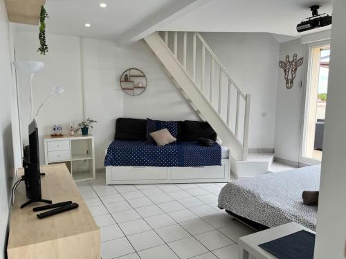 a white room with a bed and a staircase at Appartement paris Disneyland in Bussy-Saint-Georges