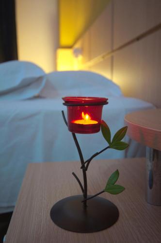a red candle on a table in a bedroom at Apartalux Magic Gold in Oropesa del Mar
