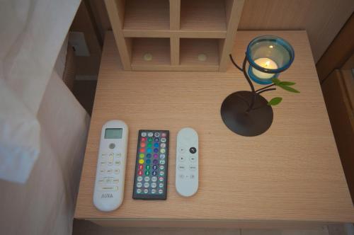 a table with two remote controls and a candle at Apartalux Magic Gold in Oropesa del Mar