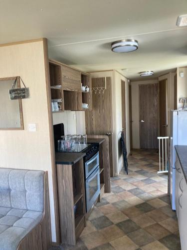 a kitchen with wooden cabinets and a counter top at A fully equiped caravan Marton mere haven in Blackpool