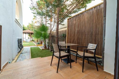 a patio with a table and chairs on a wooden deck at Alkis Guest House by AegianKazarte in Kapótidhes