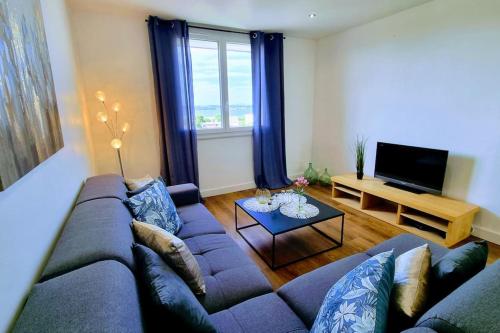 un salon avec un canapé et une télévision dans l'établissement LE CLERVILLE Rénové Terrasse Climatisation Parking, à Sète