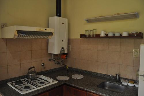 a kitchen with a stove top and a sink at Aya Bungalows in Colón