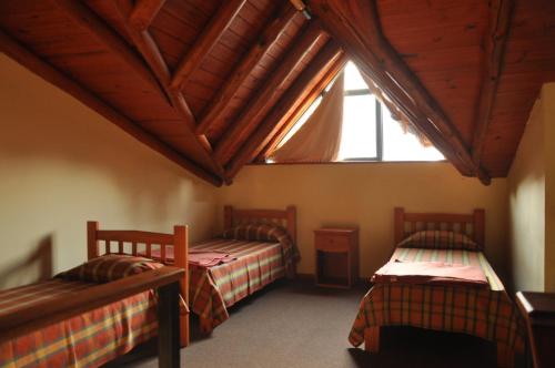 two beds in a room with a large window at Aya Bungalows in Colón