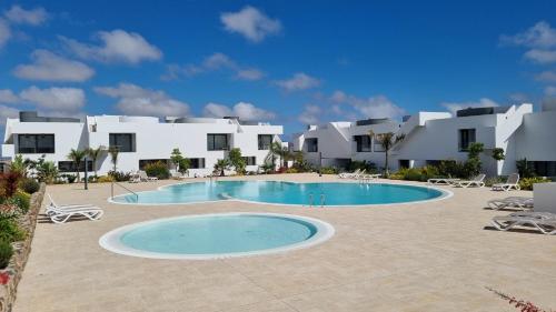 una gran piscina frente a un edificio en Superior Apartment, Casilla de Costa, en La Oliva