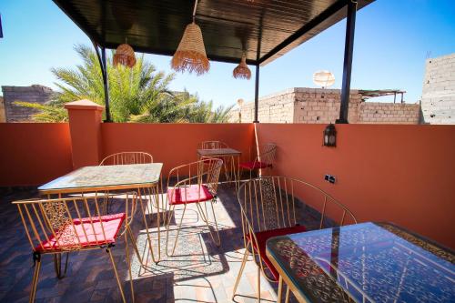 Un patio con mesas y sillas en un tejado. en Riad LALLA JIHANE, en Marrakech